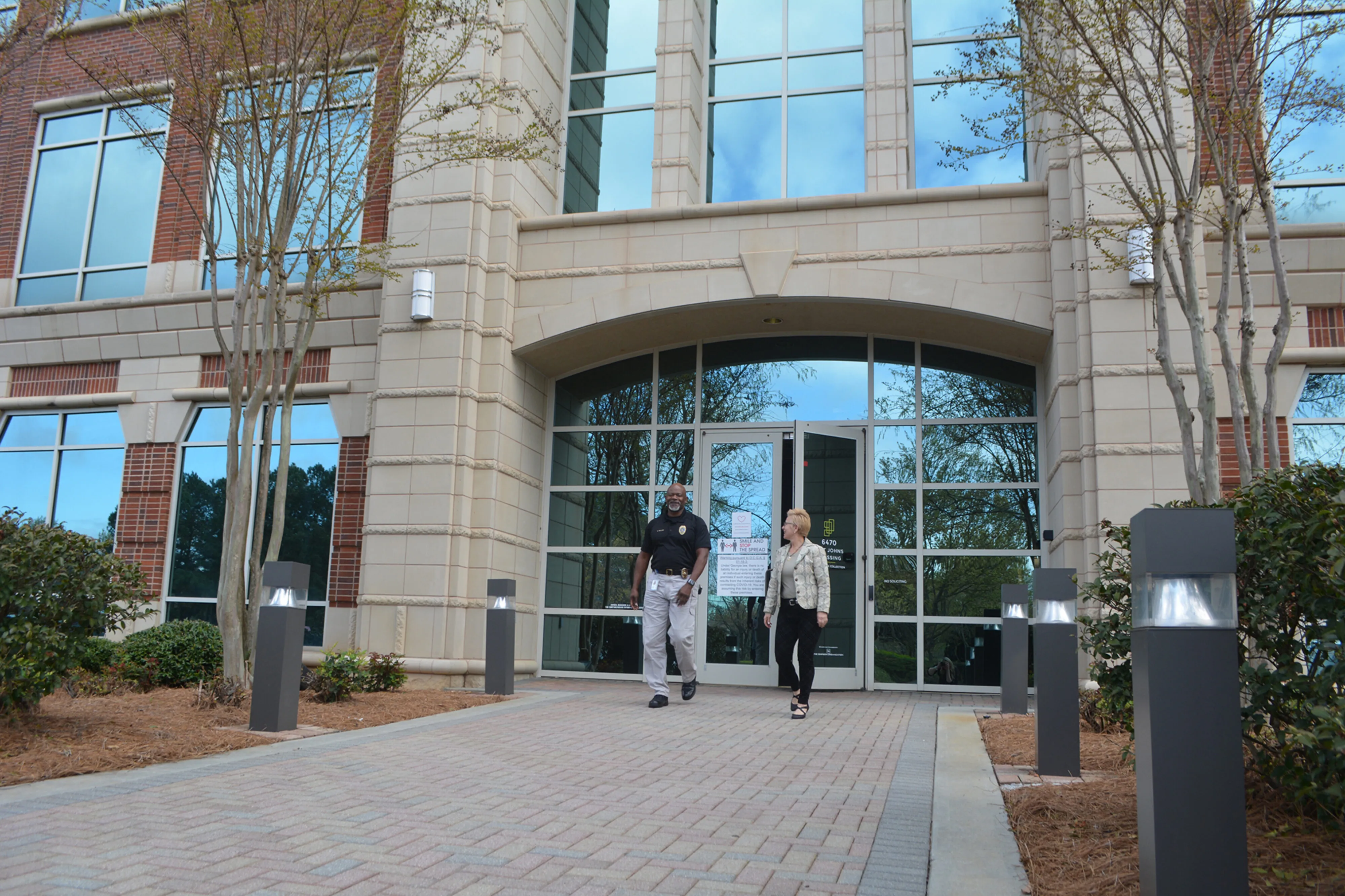 Two employees walking out of an office building in Johns Creek.