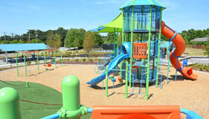 Green, blue, and orange playground equipment at Morton Road Park