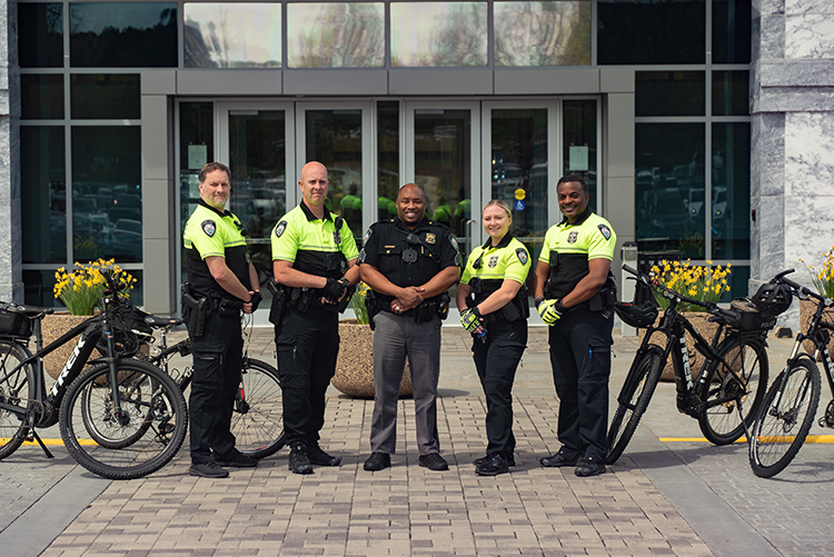 Five officers in front of City Hall with their bikes
